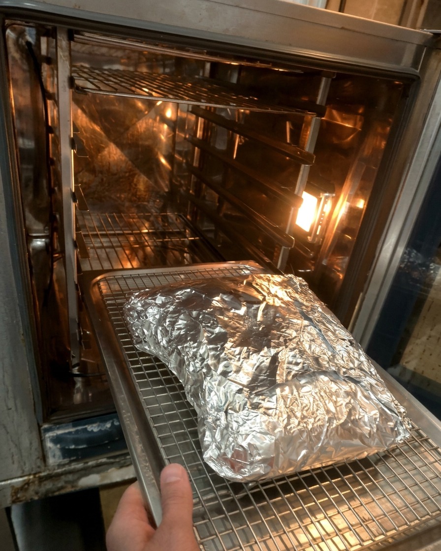 Le paquet daluminium contenant les côtes placé sur une grille à lintérieur dun four chaud.