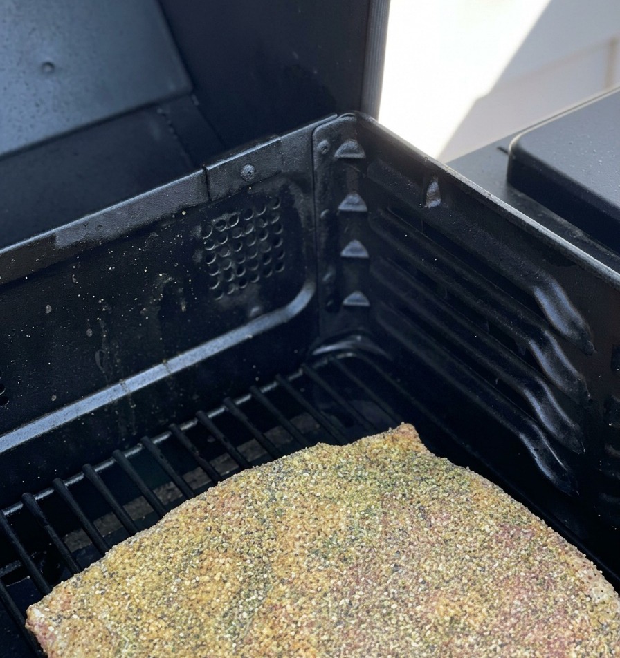Côtes de bœuf crues et assaisonnées posées sur les grilles dun fumoir.