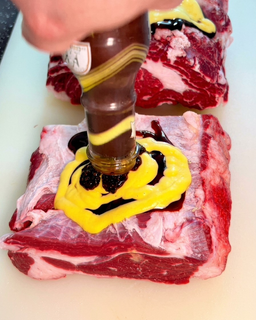 Sauce au poivre noir épaisse versée sur la couche de moutarde.