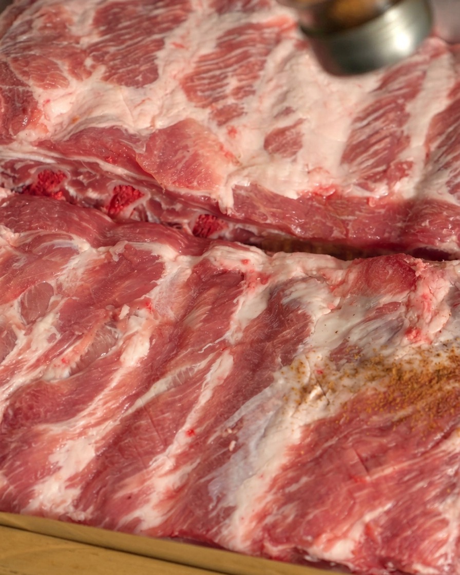 Épices sèches saupoudrées sur la surface de travers de porc crus.