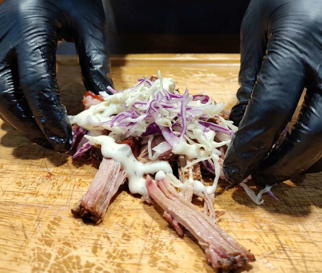 Vinaigrette crémeuse blanche versée sur le mélange de porc et de coleslaw.
