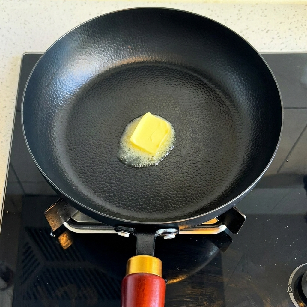 Une noisette de beurre fondant dans la poêle propre.