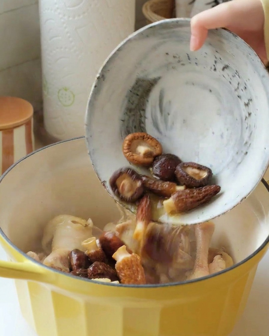 Verser les champignons réhydratés dans la cocotte contenant le poulet.