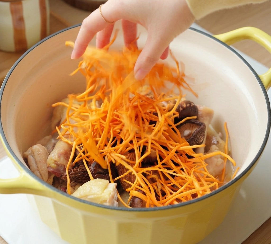 Une main parsemant des fleurs de cordyceps orange vif sur le poulet et les champignons.