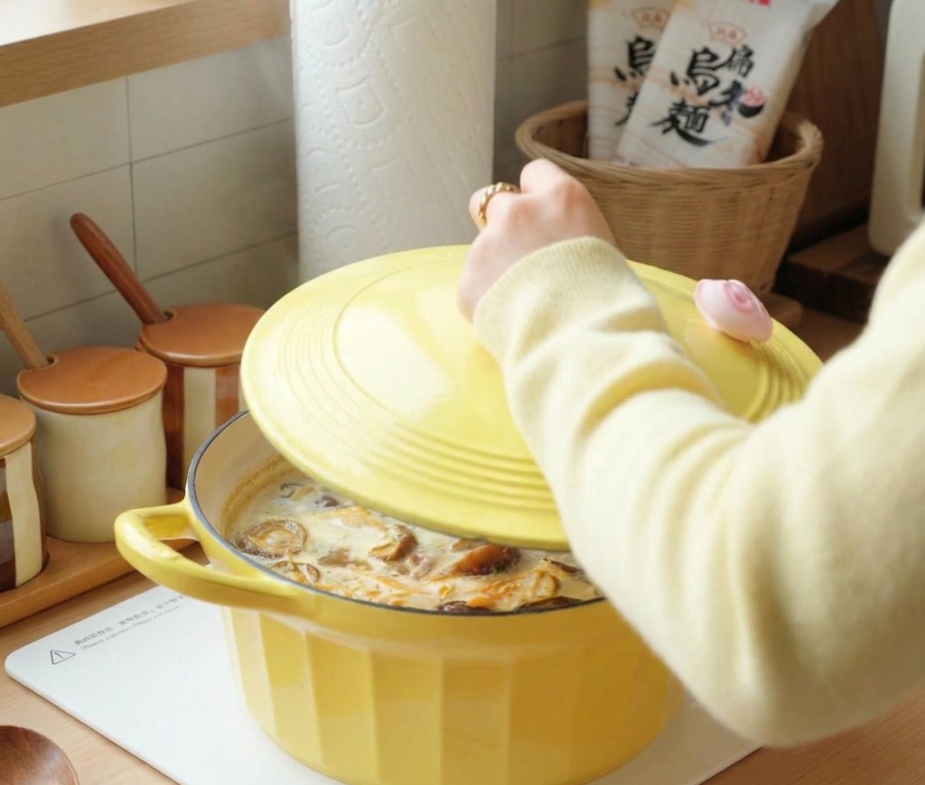 Une personne posant le couvercle sur une cocotte de soupe frémissante.