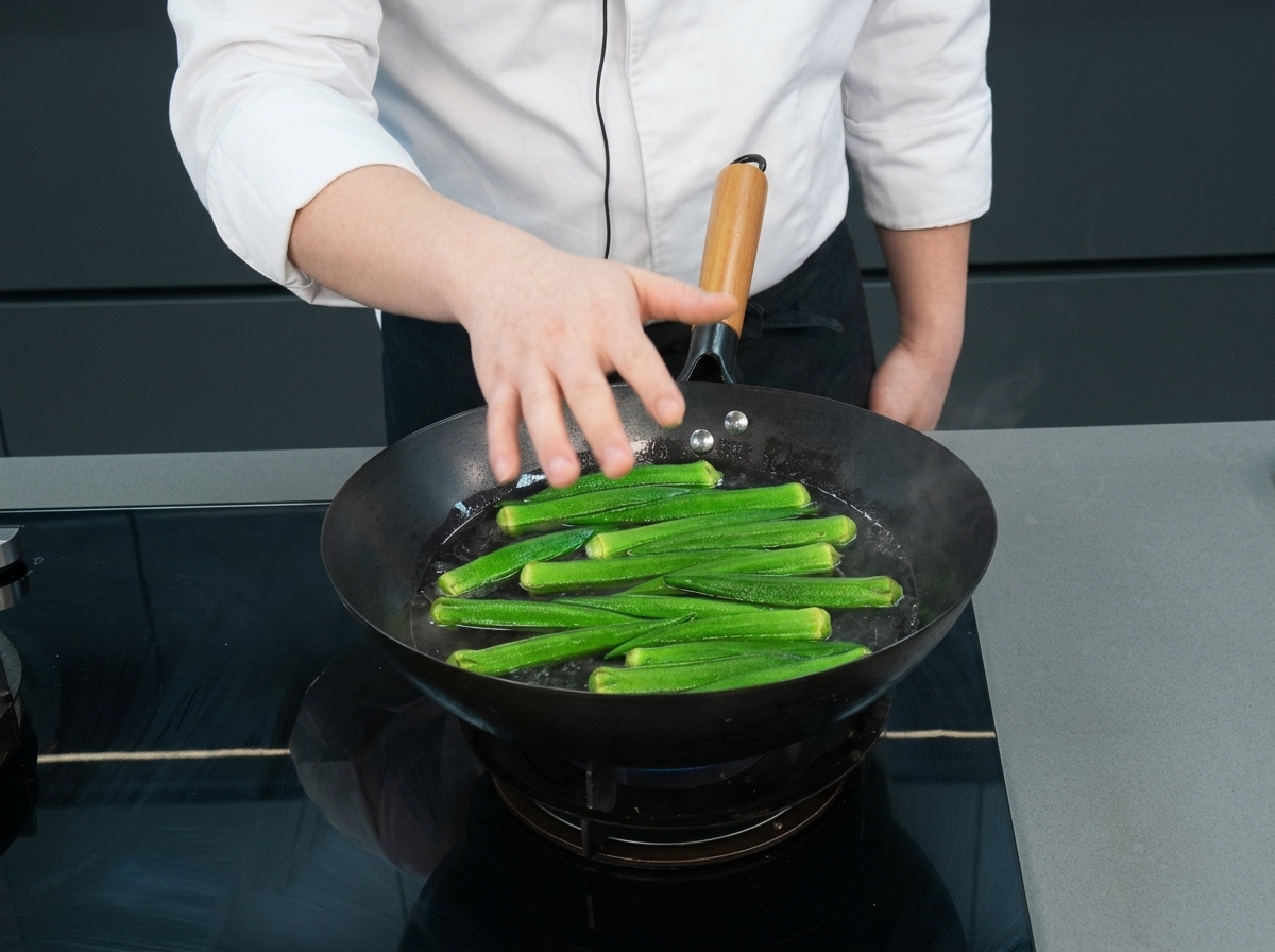 Gombos verts entiers flottant dans un wok deau bouillante.
