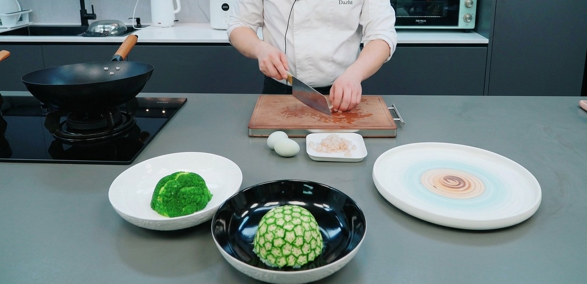 Mains utilisant un couperet pour couper de la viande séchée rouge sur une planche en bois.