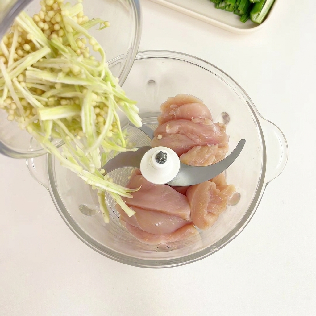 Graines et pulpe de gombo versées dun bol en verre dans un mixeur contenant le poulet.