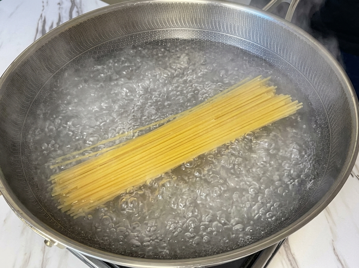 Spaghettis secs immergés dans une grande casserole deau bouillante.