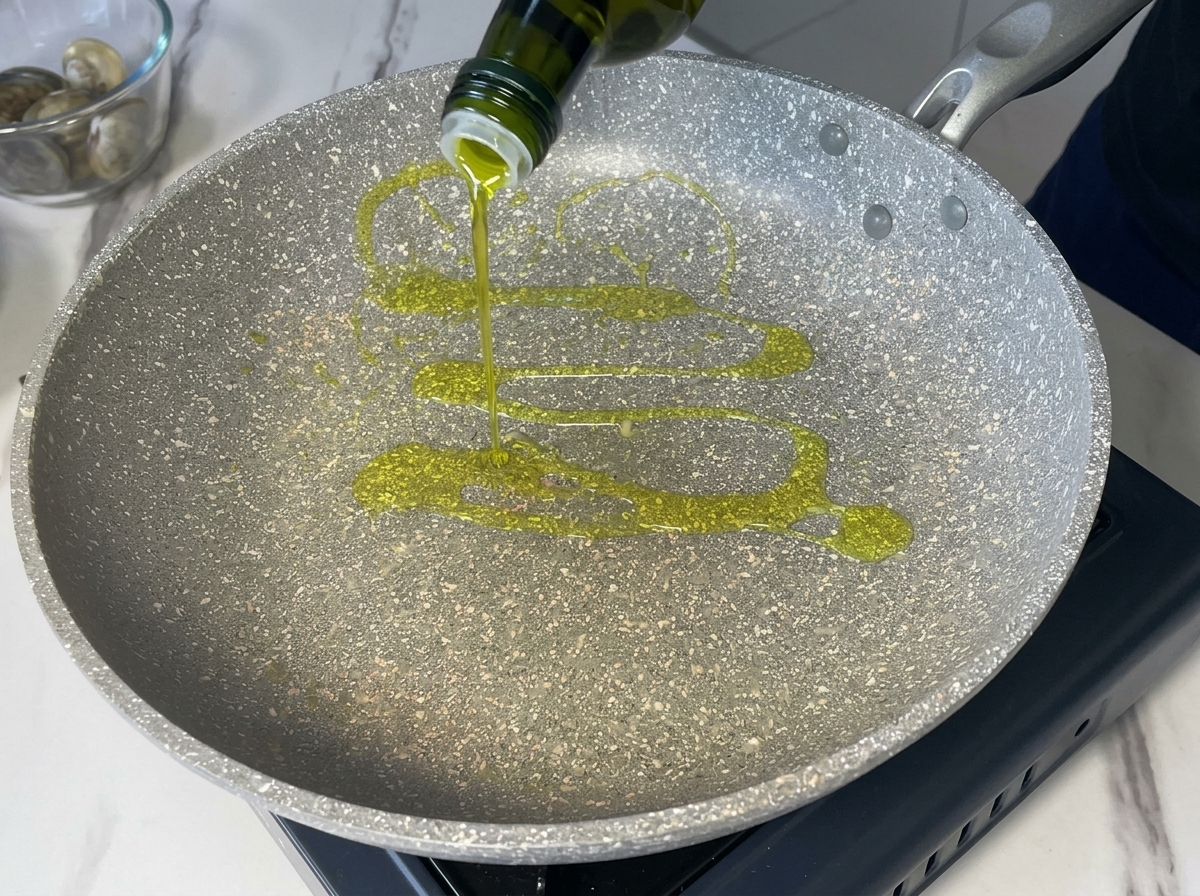 Verser de lhuile dolive extra vierge dune bouteille foncée dans une poêle grise.