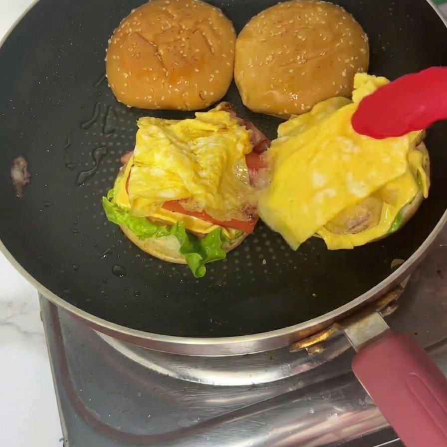 Le burger déjeuner terminé sur une assiette avec le chapeau au sésame bien en place.