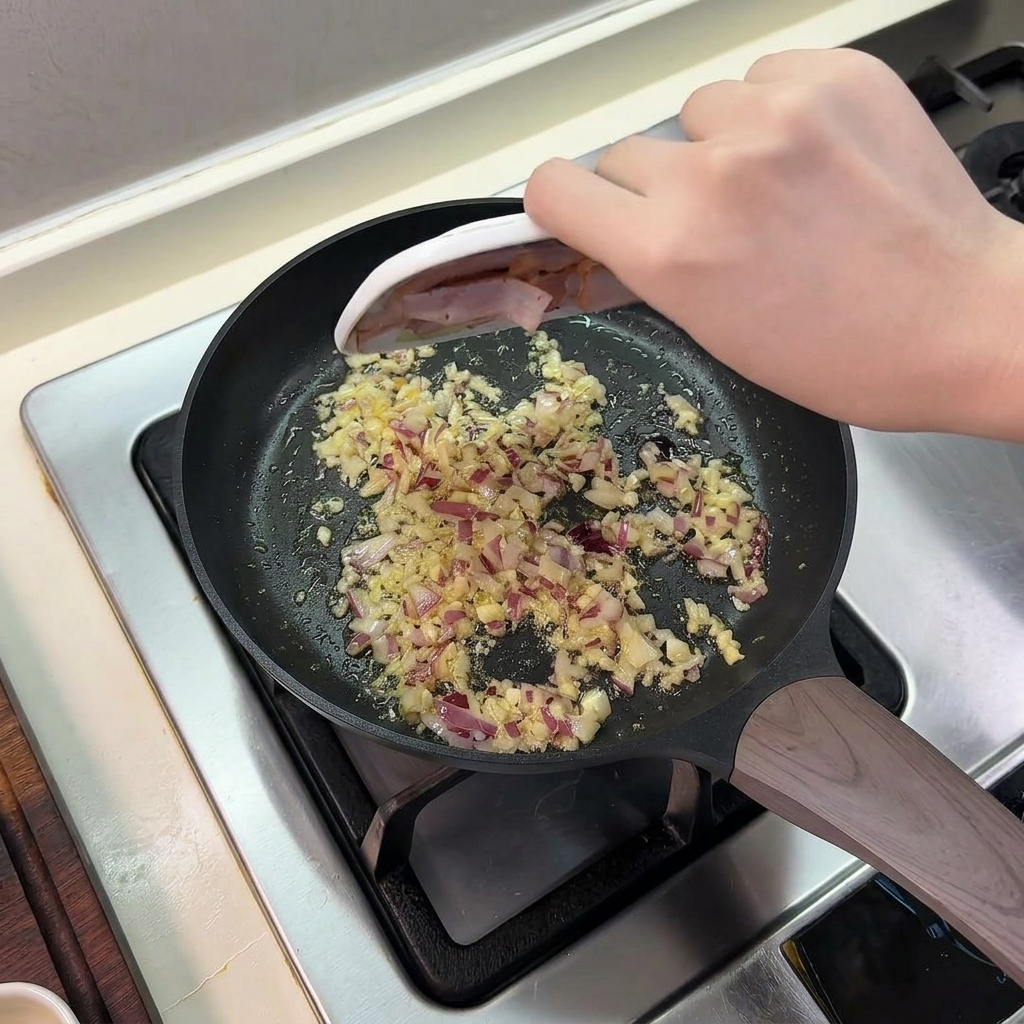 Lardons glissés depuis une petite assiette dans la poêle contenant les oignons et lail sautés.
