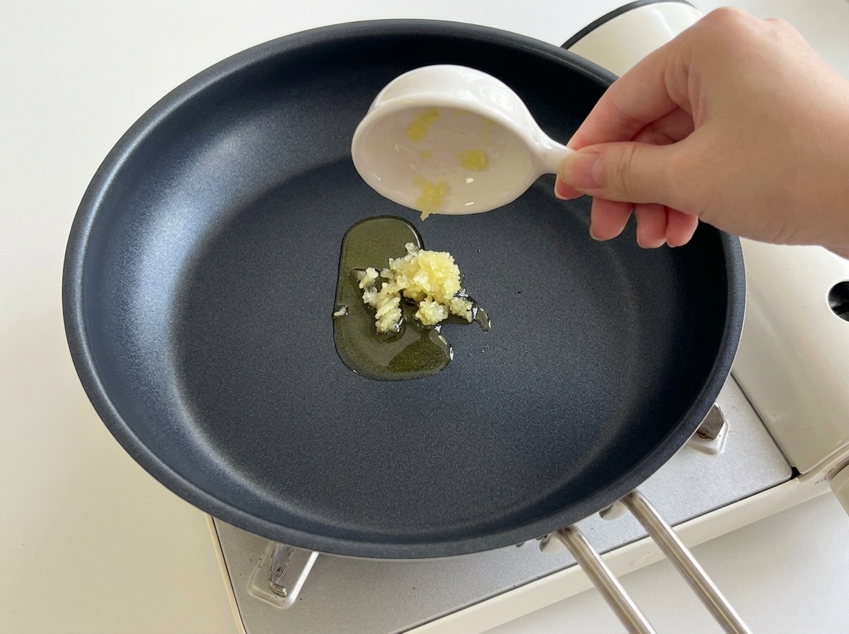Ail haché versé dans une poêle chaude avec de lhuile.