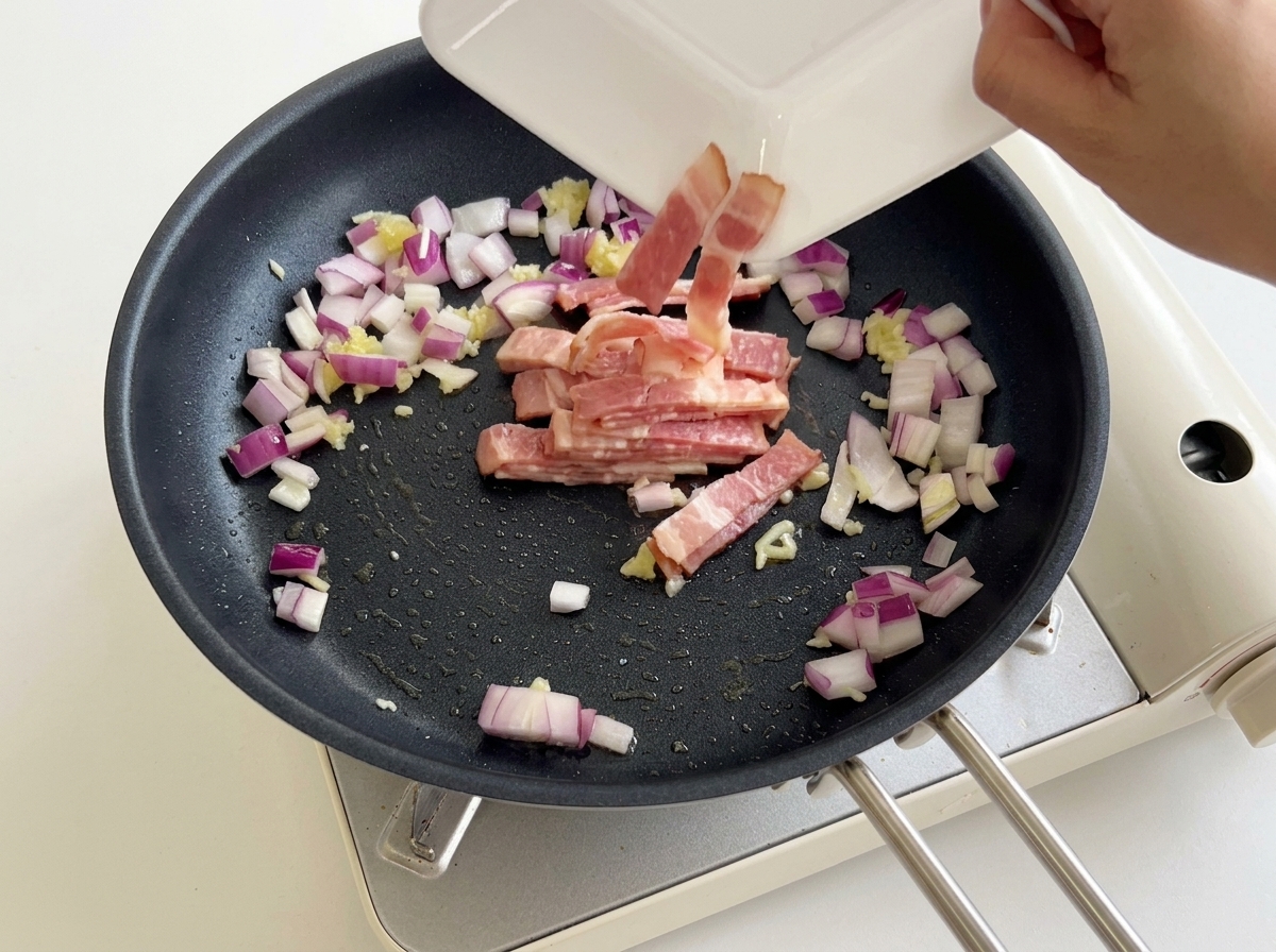 Morceaux de bacon versés dans la poêle avec les oignons et lail.