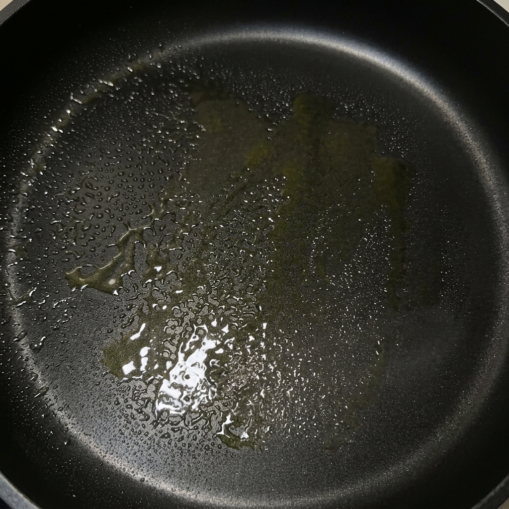 Une poêle noire nappée dun mélange brillant de beurre fondu et dhuile dolive.