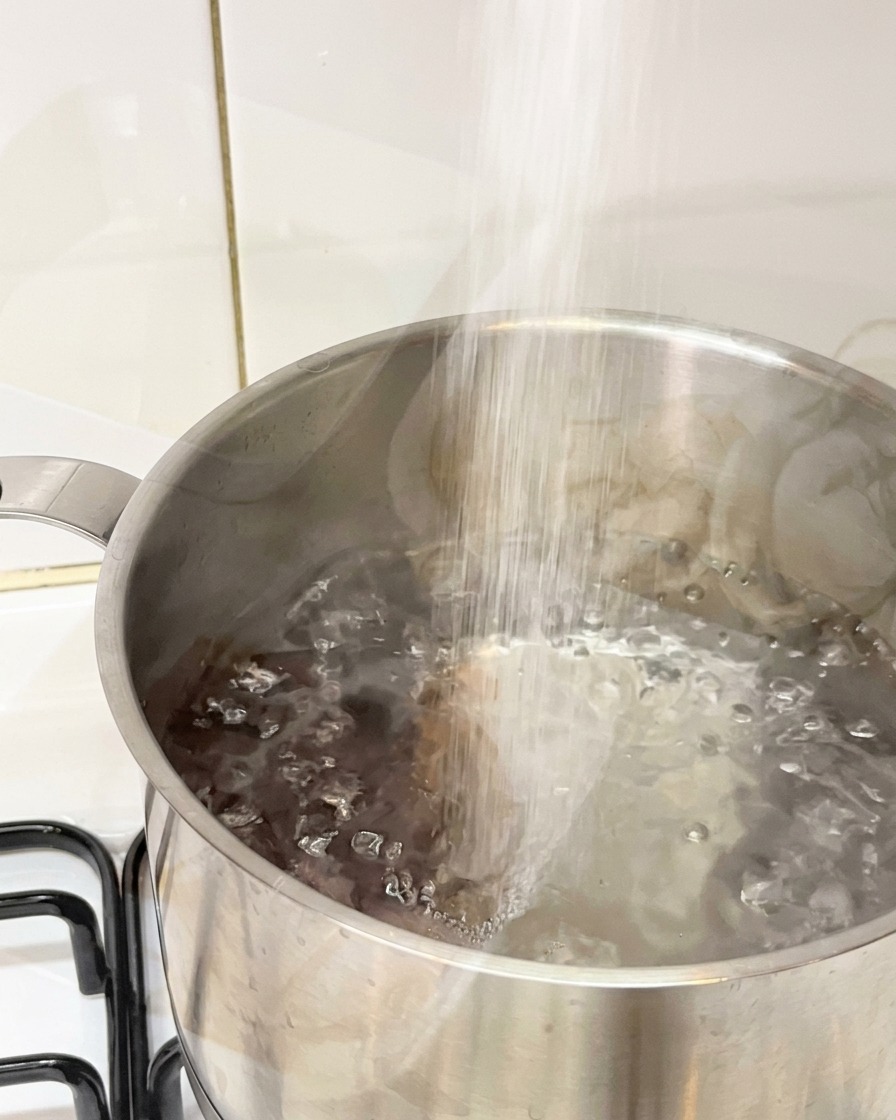 Sel versé dans une casserole deau bouillante.