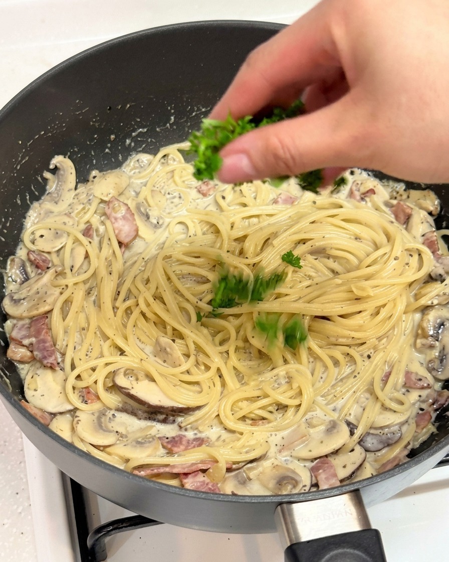 Main parsemant du persil haché sur les pâtes à la truffe.
