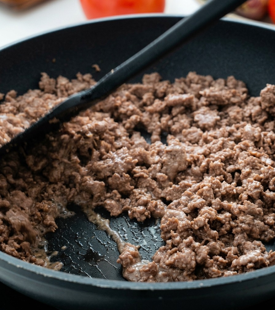 Bœuf haché bien cuit et émietté sauté dans une poêle.