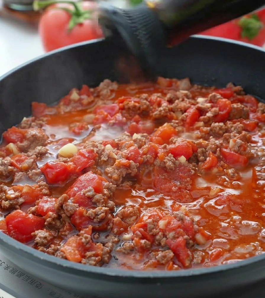 Sauce dhuître versée dans la sauce tomate et bœuf frémissante.
