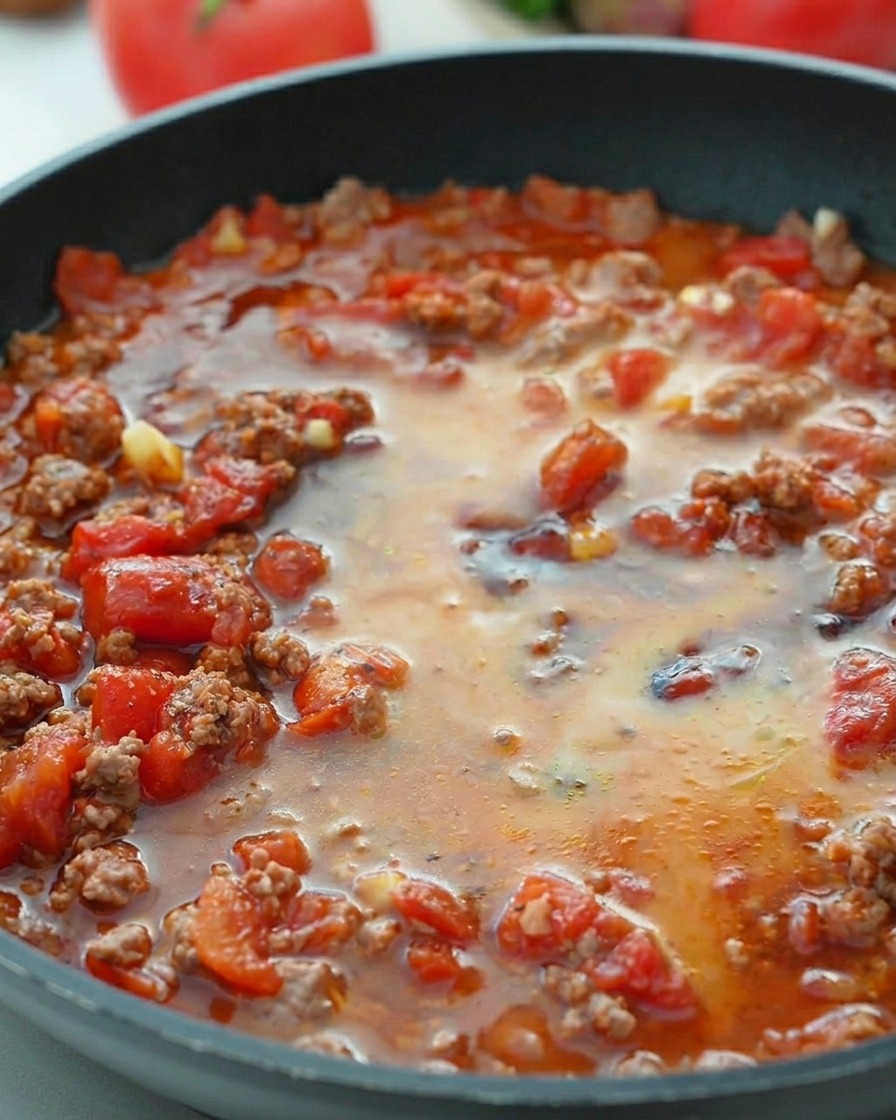 Eau amidonnée versée dans la sauce tomate frémissante.