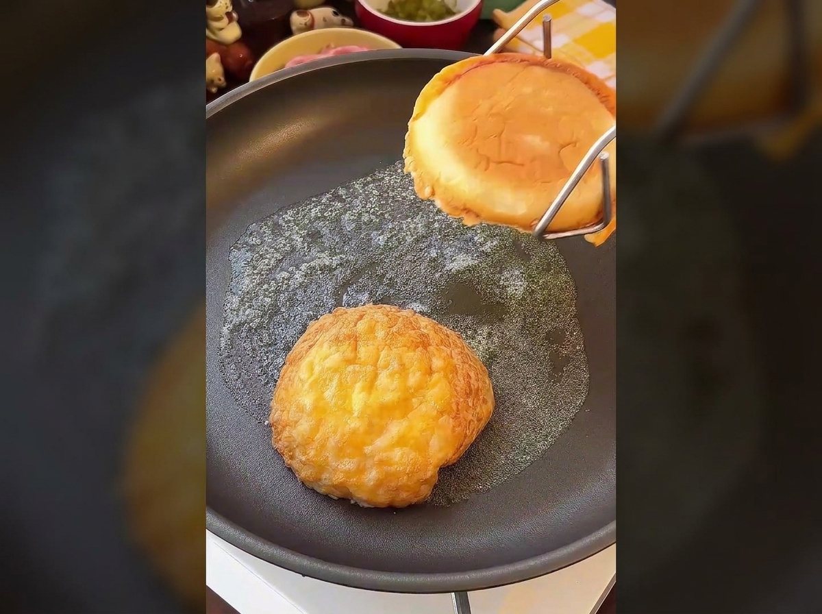 Deux moitiés de pain burger grillées face contre poêle dans du beurre fondu jusquà coloration dorée.