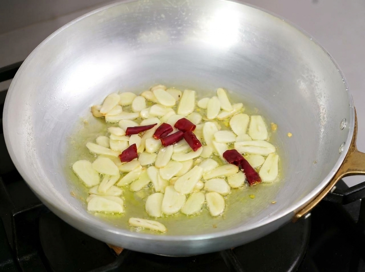 Ail tranché et morceaux de piment rouge frémissant ensemble dans lhuile dolive.