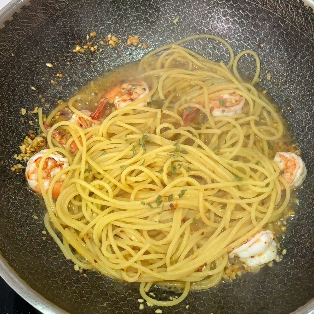 Spaghettis et crevettes dans un wok chaud garnies de persil vert frais haché.