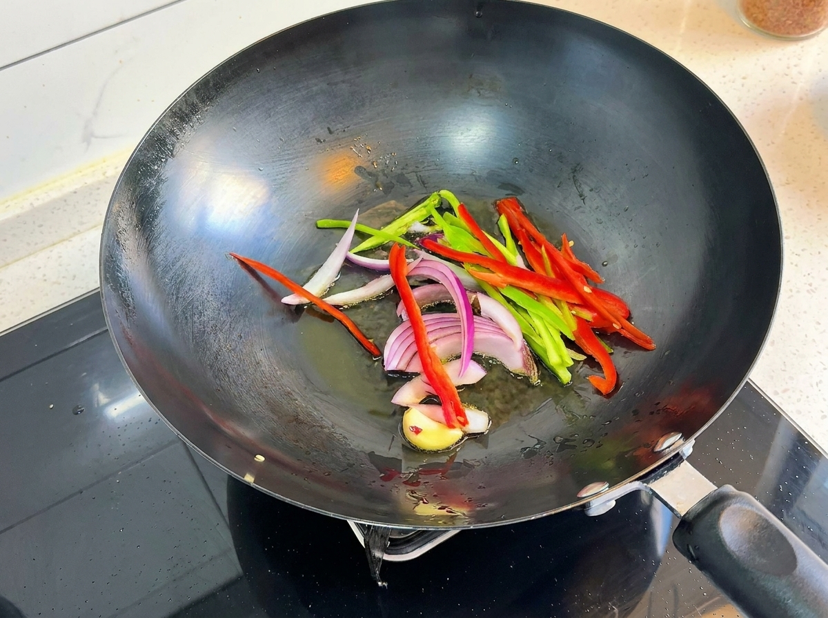 Poivrons, oignons et ail crépitant dans un wok chaud.