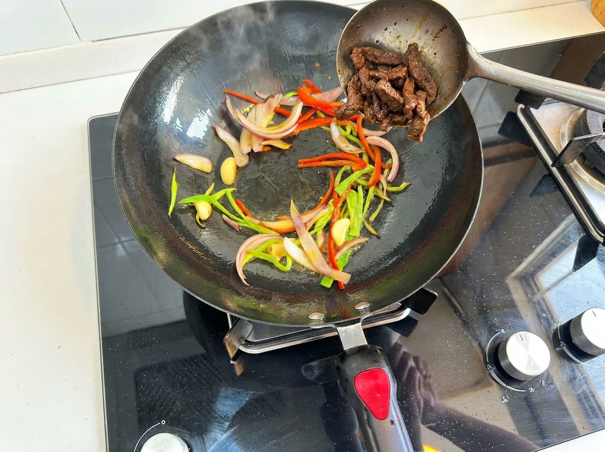 Lamelles de bœuf rajoutées dans le wok avec les légumes sautés.