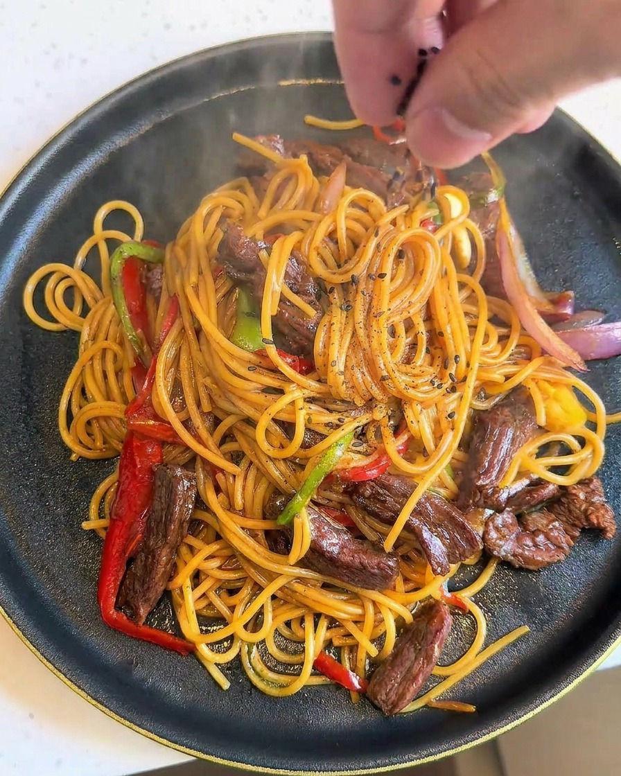 Graines de sésame noir saupoudrées sur le plat fini.
