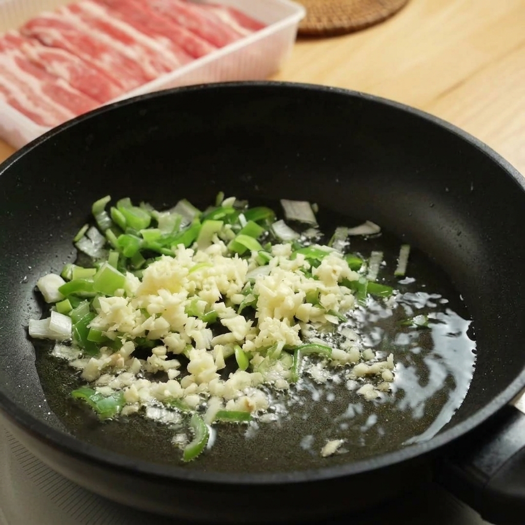 Ail et oignons verts crépitant dans une poêle chaude.