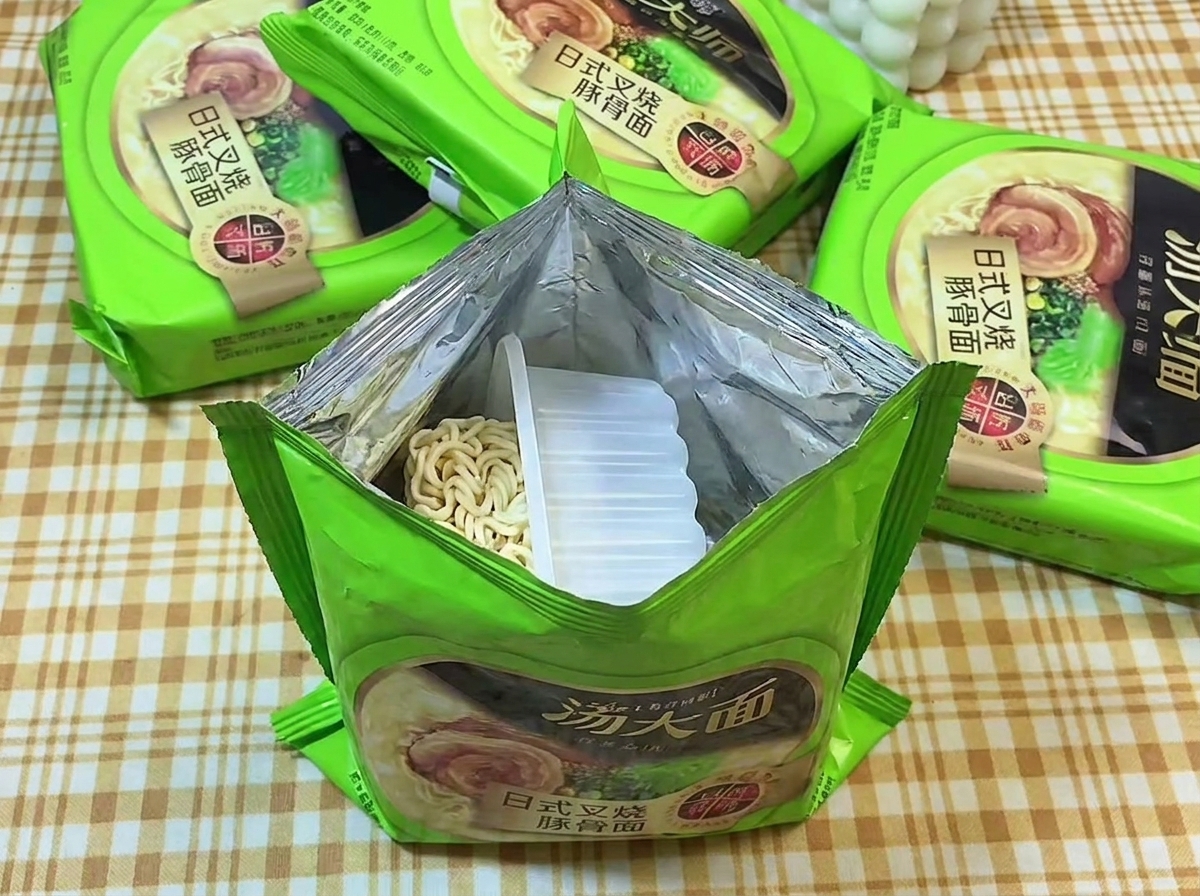 Paquet vert de ramen instantané ouvert révélant un bloc de nouilles ondulées dans un plateau en plastique.
