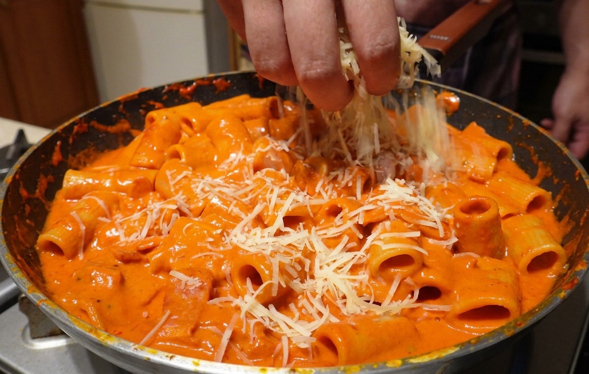 Parmesan râpé saupoudré à la main sur des rigatoni mélangés à une sauce vodka rose crémeuse.