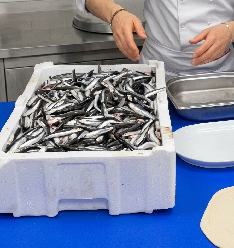 Un chef manipulant une caisse danchois frais et argentés.