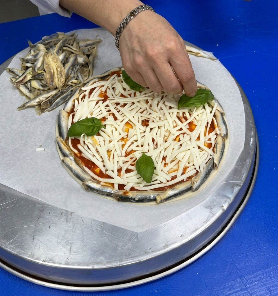 Main déposant des feuilles de basilic frais sur le fromage râpé.