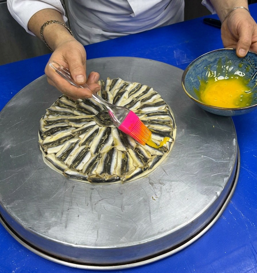 Pinceau en silicone appliquant un jaune dœuf sur la pizza garnie danchois.