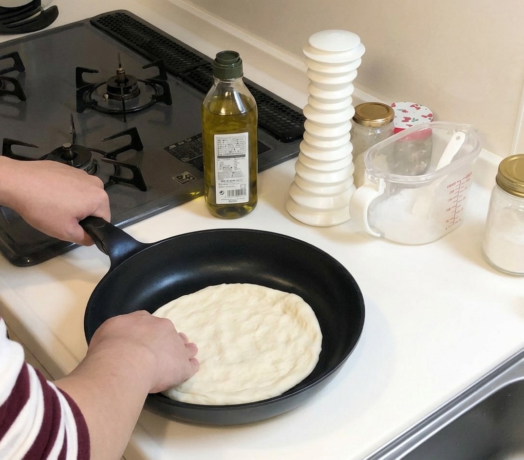 Des mains pressant et étalant un morceau de pâte à pizza crue vers les bords dune poêle noire froide.