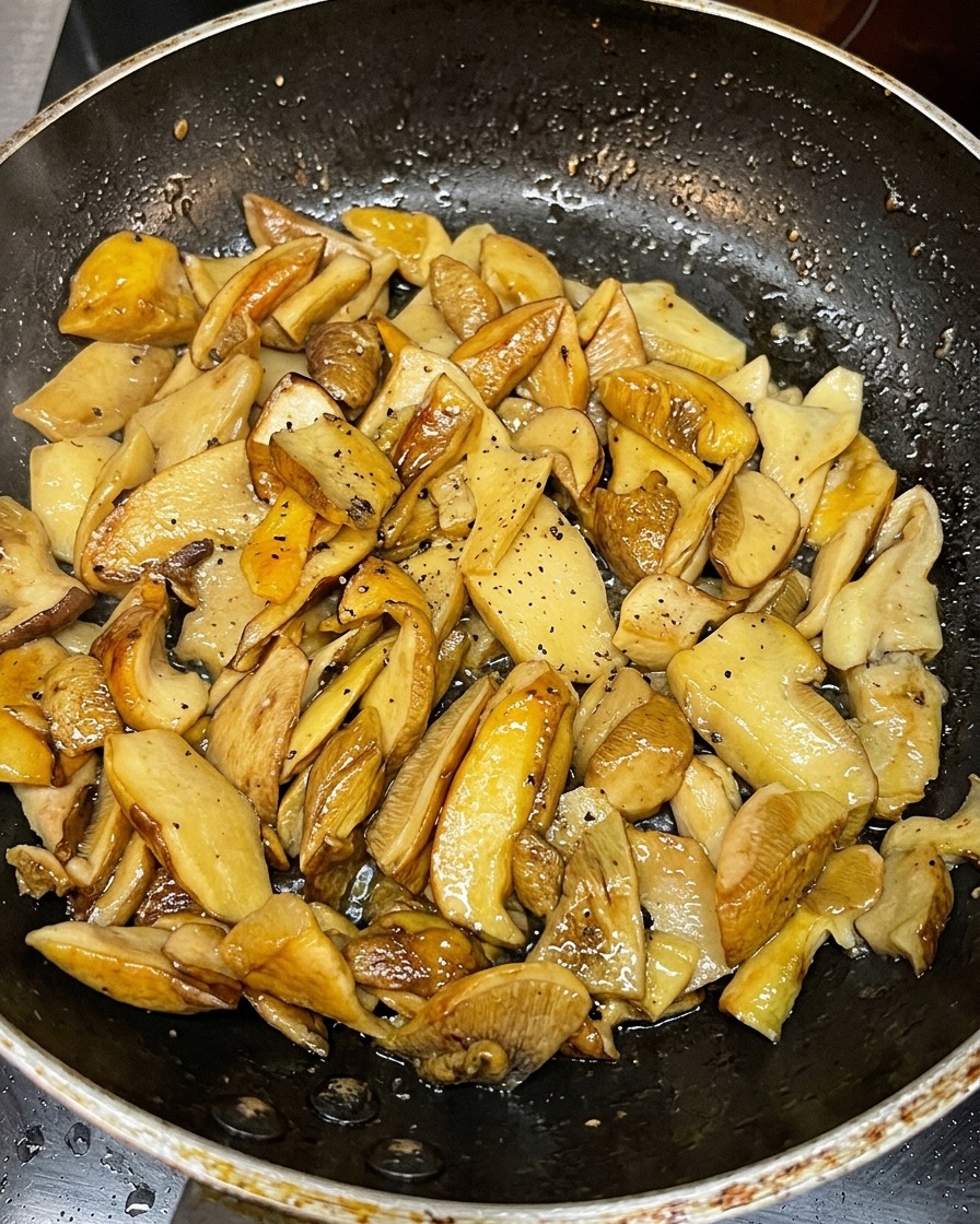 Tranches de champignons dorées poêlées dans une poêle chaude.