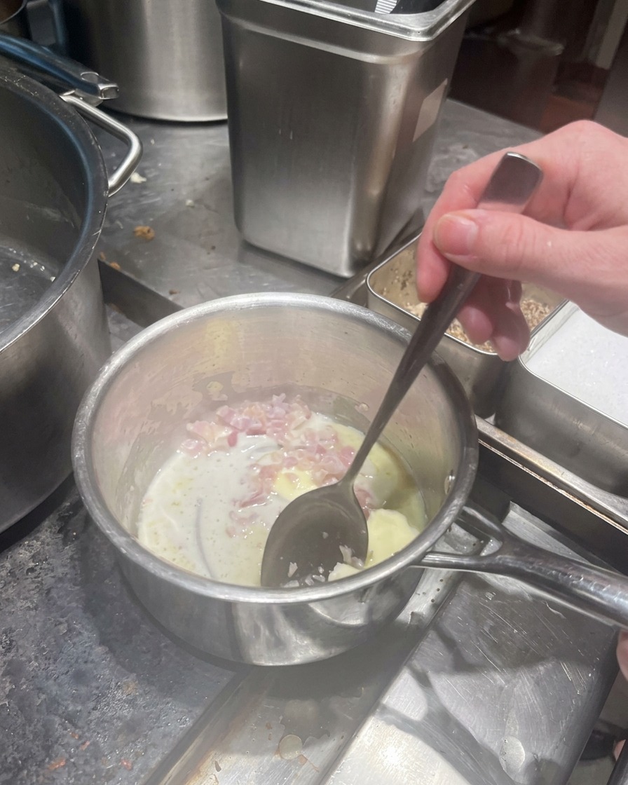 Dés déchalotes cuisant dans du beurre fondu dans une petite casserole.