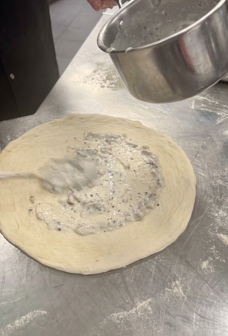 Étaler la sauce crémeuse aux champignons au centre de la pâte avec une cuillère.
