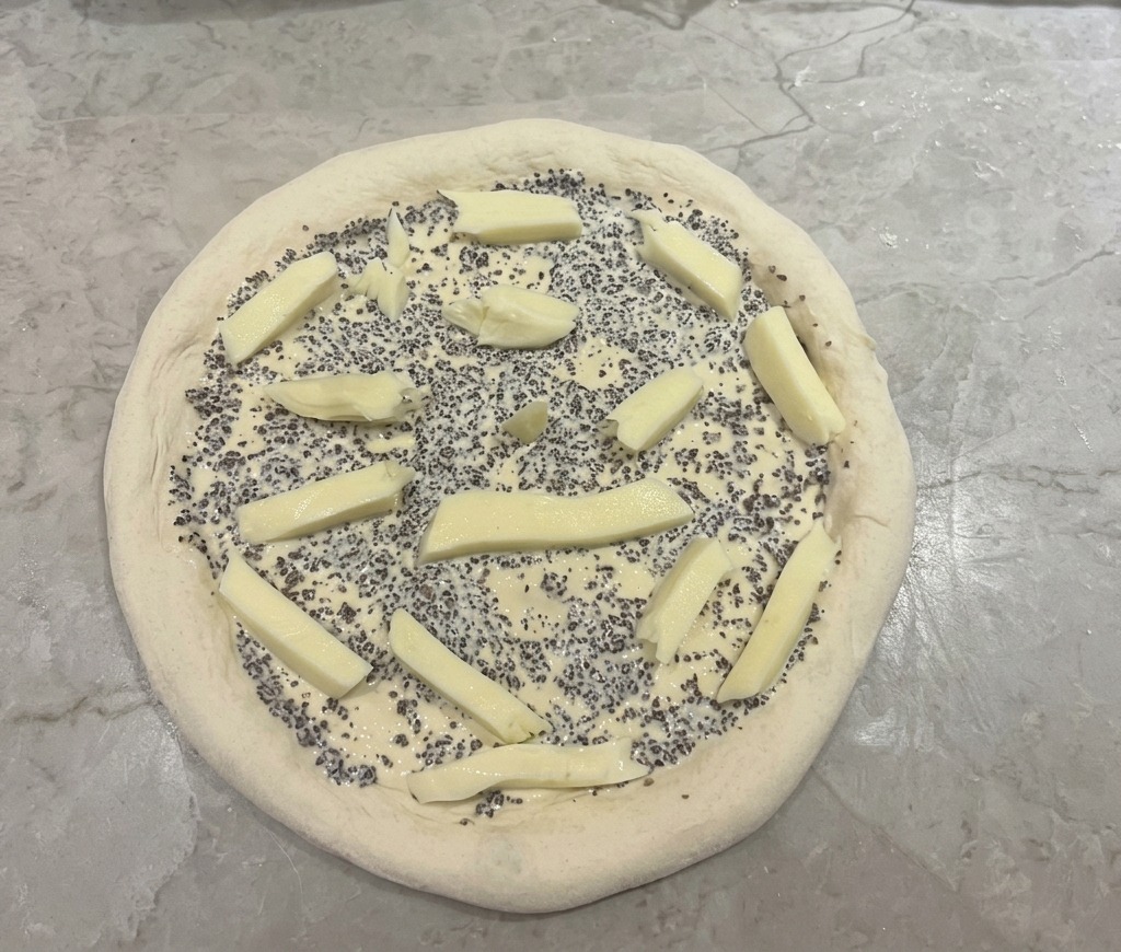 Pâte à pizza garnie de sauce à la truffe et de morceaux de mozzarella.