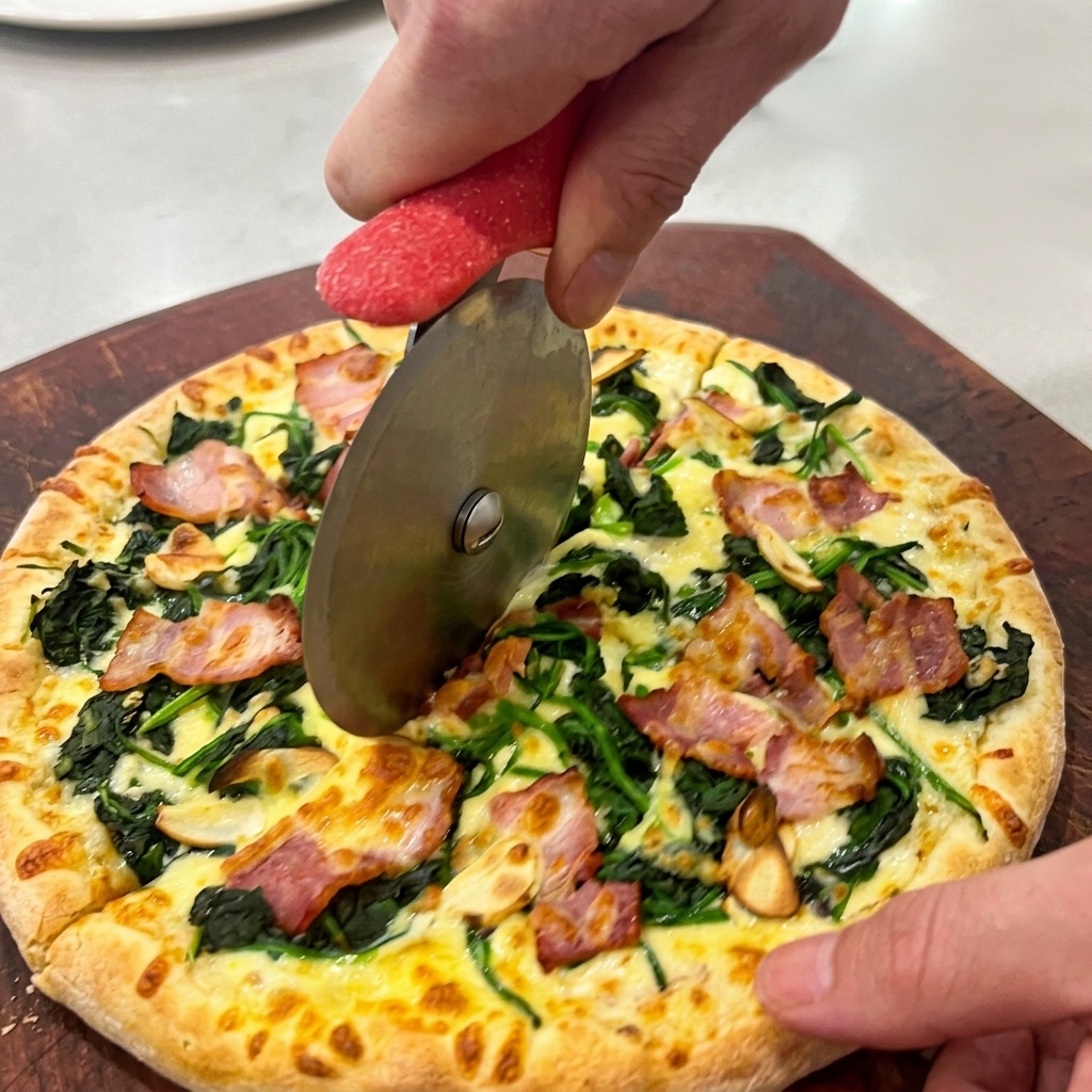 Mains utilisant une roulette à pizza pour couper des parts régulières sur une planche en bois.