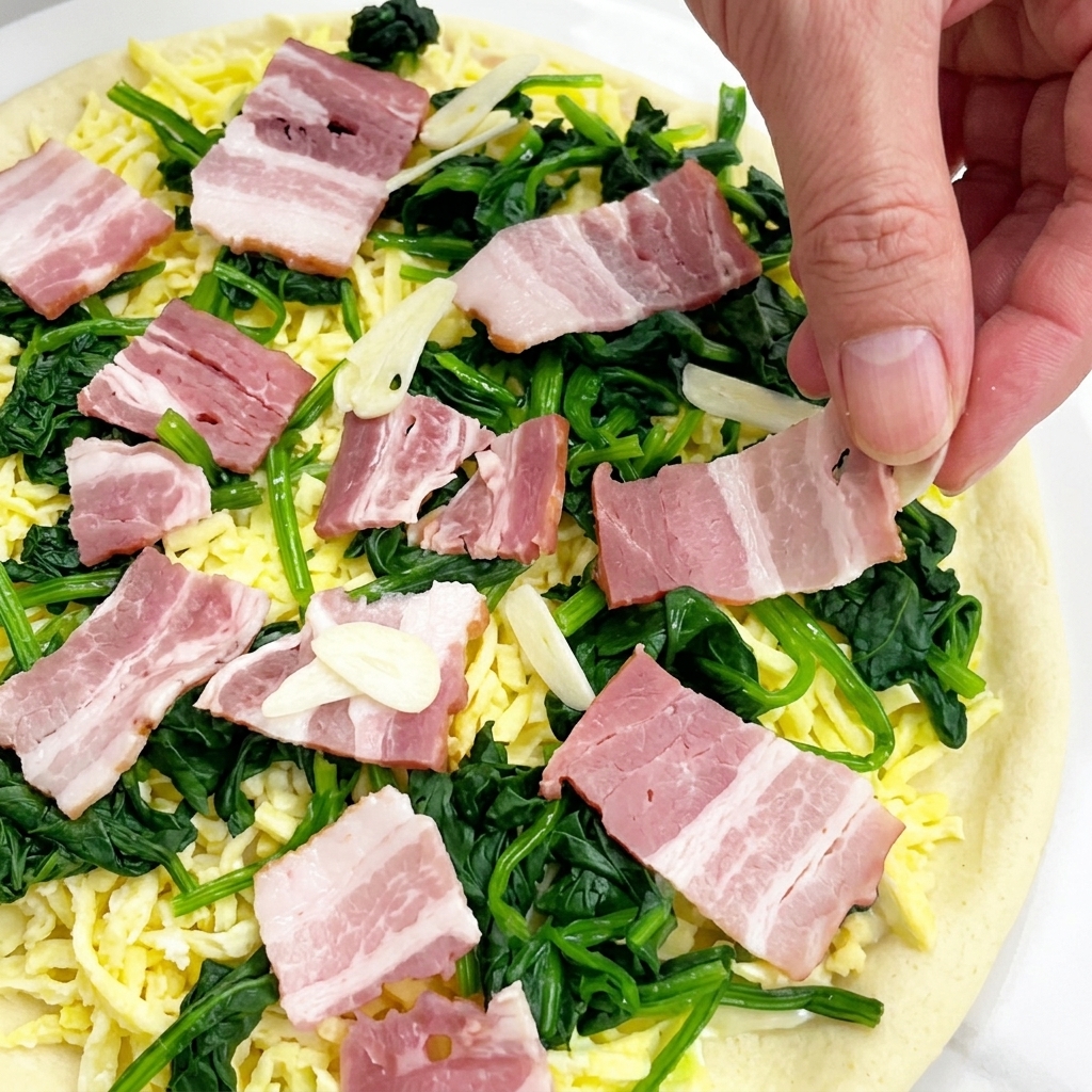 Main laissant tomber de fines tranches dail cru sur une pizza prête à cuire.