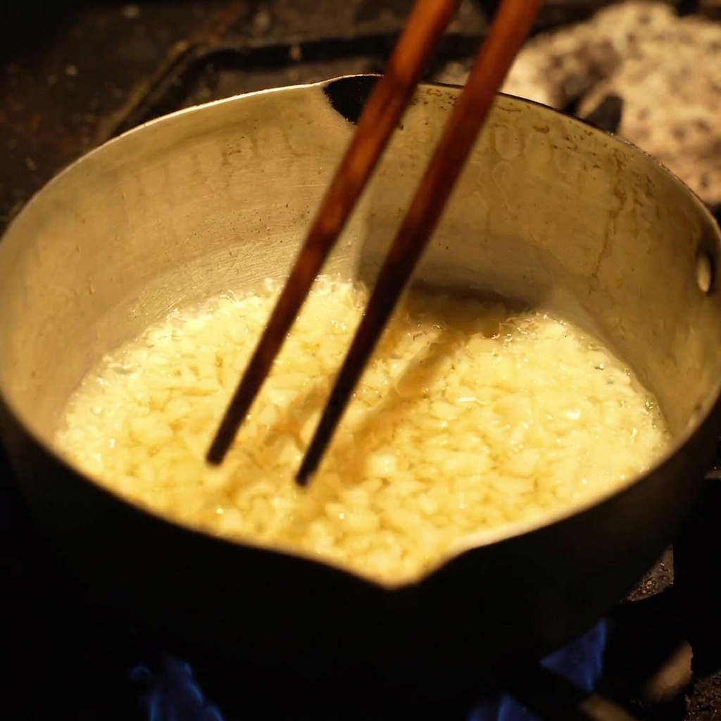 Morceaux dail frites bouillonnant vigoureusement dans lhuile chaude à lintérieur dune casserole métallique.