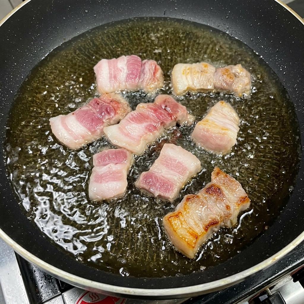 Tranches épaisses de poitrine de porc dorant dans une poêle avec de lhuile.