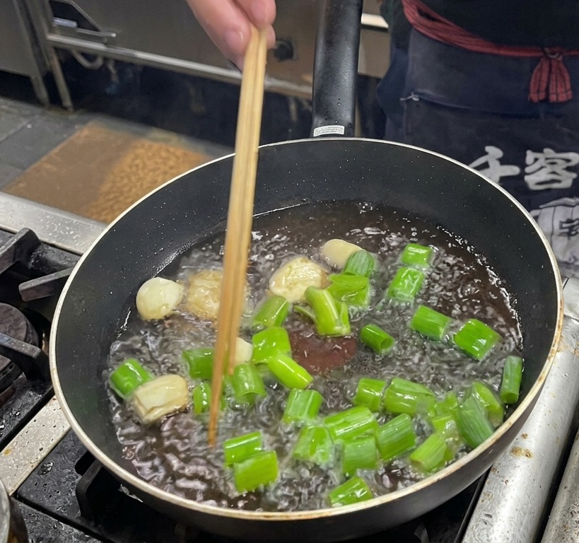 Friture de gros morceaux de ciboule, dail et de gingembre dans le gras de porc.