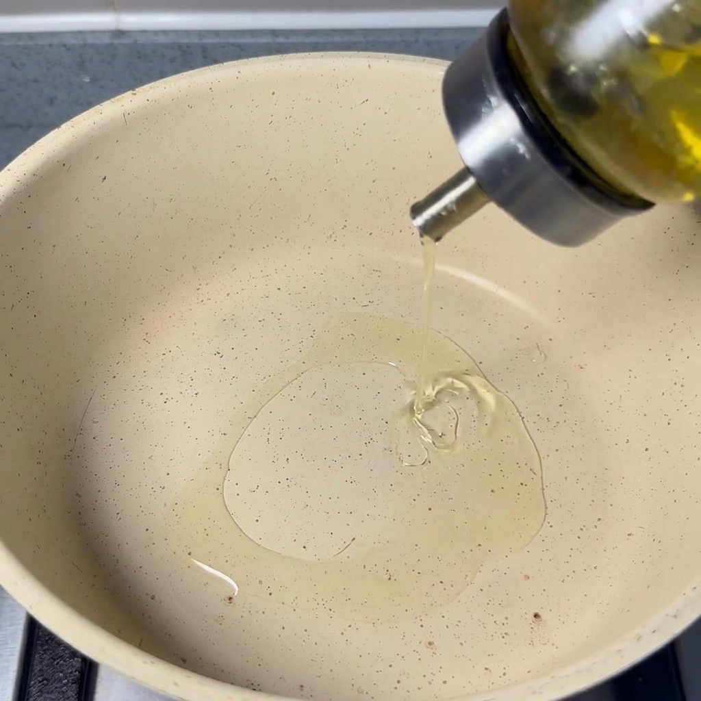 Huile de cuisson versée dune bouteille en verre dans une poêle claire.