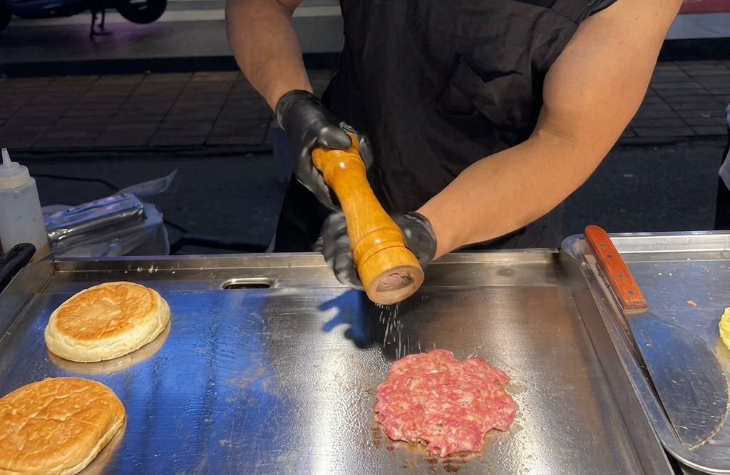 Moulage de sel de mer et de poivre noir sur un steak de bœuf grésillant sur une plaque.