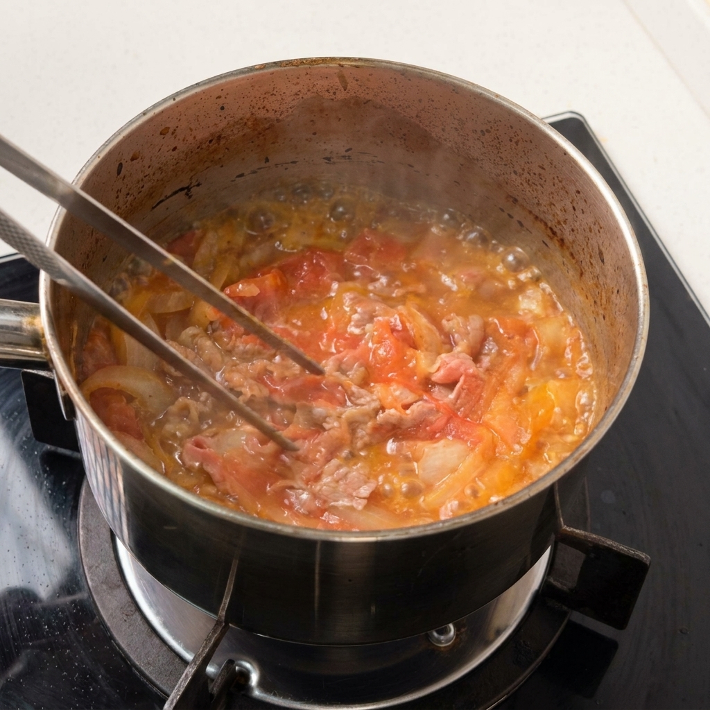 De fines tranches de bœuf et des oignons mijotant doucement dans un fond de sauce brune.