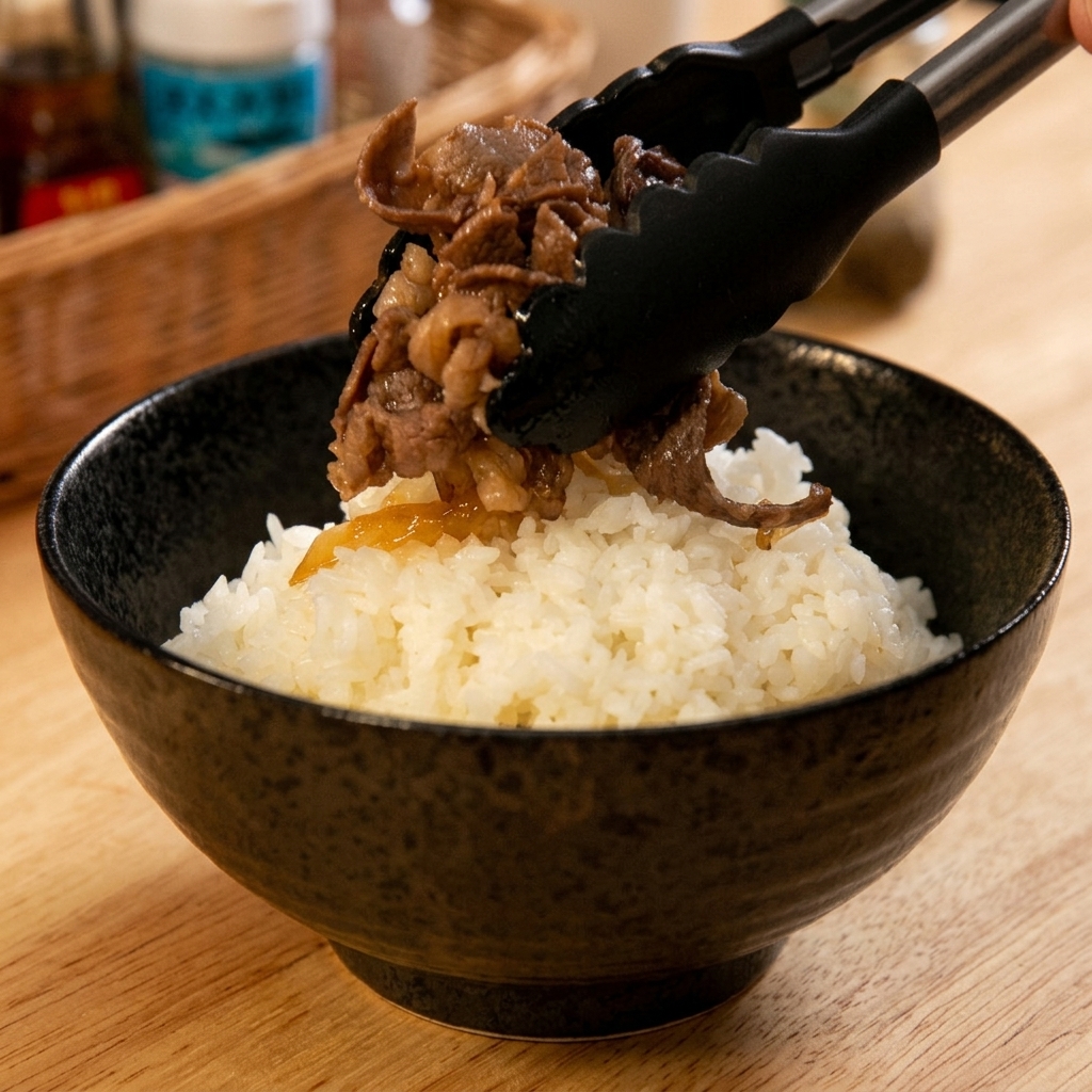 Une pince de cuisine déposant délicatement une généreuse portion de bœuf et doignons mijotés sur un bol de riz blanc.